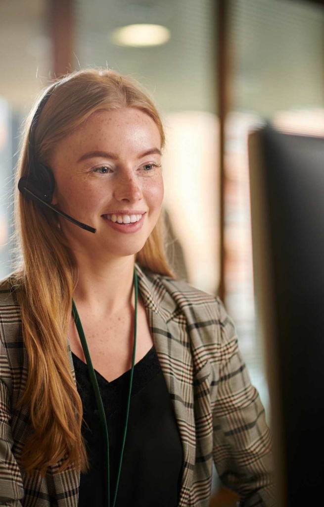Photo of young woman in business clothes with long hair wearing a headset
